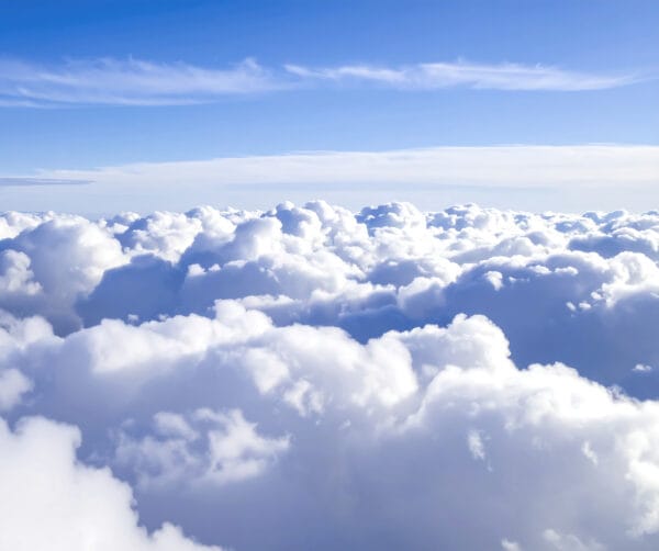 A vast expanse of fluffy white clouds against a vibrant blue sky